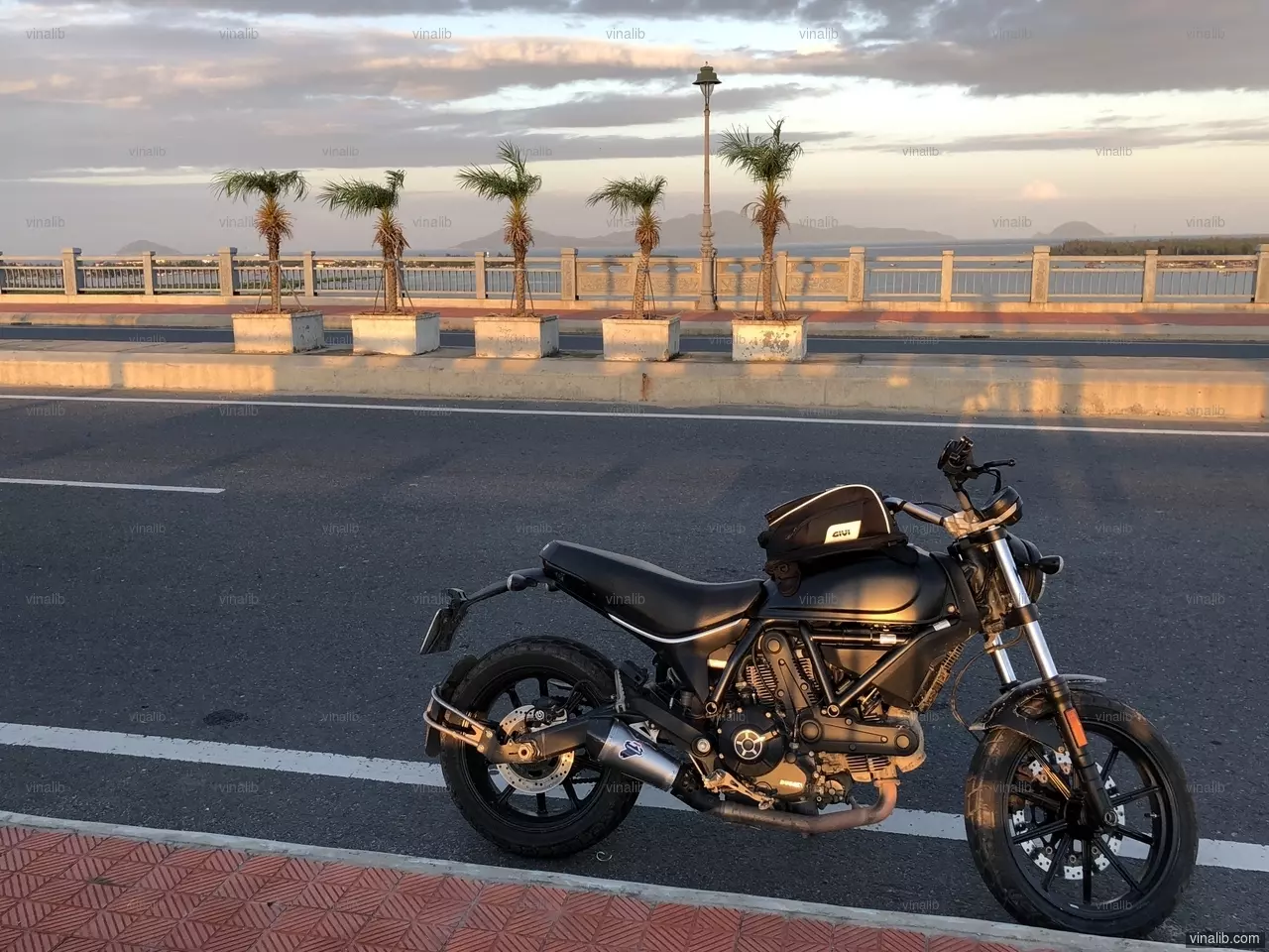 A Ducati Scrambler on Cua Dai bridge, Hoi An, Vietnam - Vinalib Stock Pictures